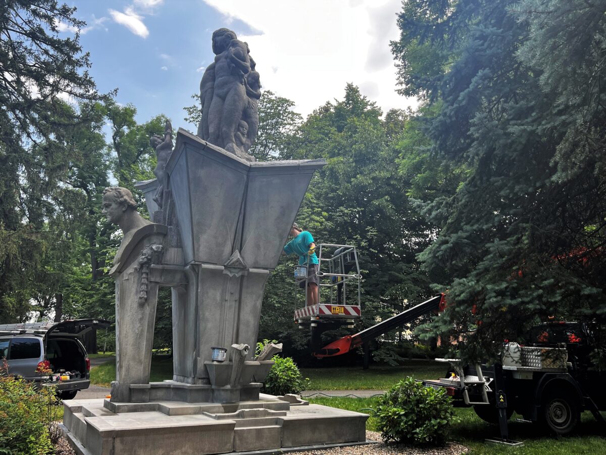 Pracovník na plošině provádějící restaurátorské práce na pomníku J. G. Mendela ve Smetanových sadech
